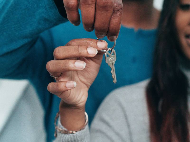 Two people holding the keys to a new home